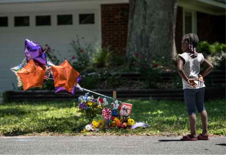 A young girl observes Ahmaud Arbery memorial