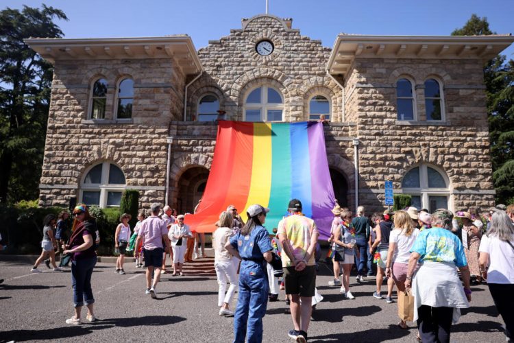 A giant Pride flag is unfurled at Sonoma City Hall during the Sonoma Valley Pride Festival at Sonoma Plaza in Sonoma Sunday, June 1, 2025. (Beth Schlanker / The Press Democrat)